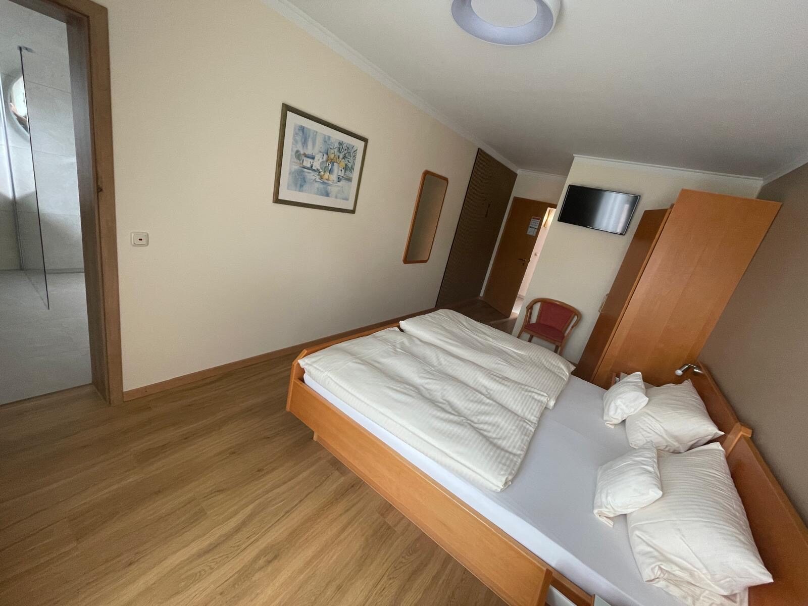 Doppelzimmer mit Doppelbett und Kleiderschrank im Landhaus Schend