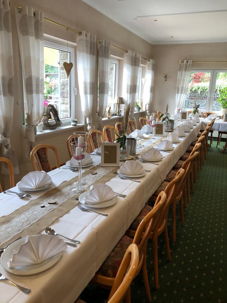 Table de fête claire au Landhaus Schend avec serviettes blanches en éventail, à la lumière du jour